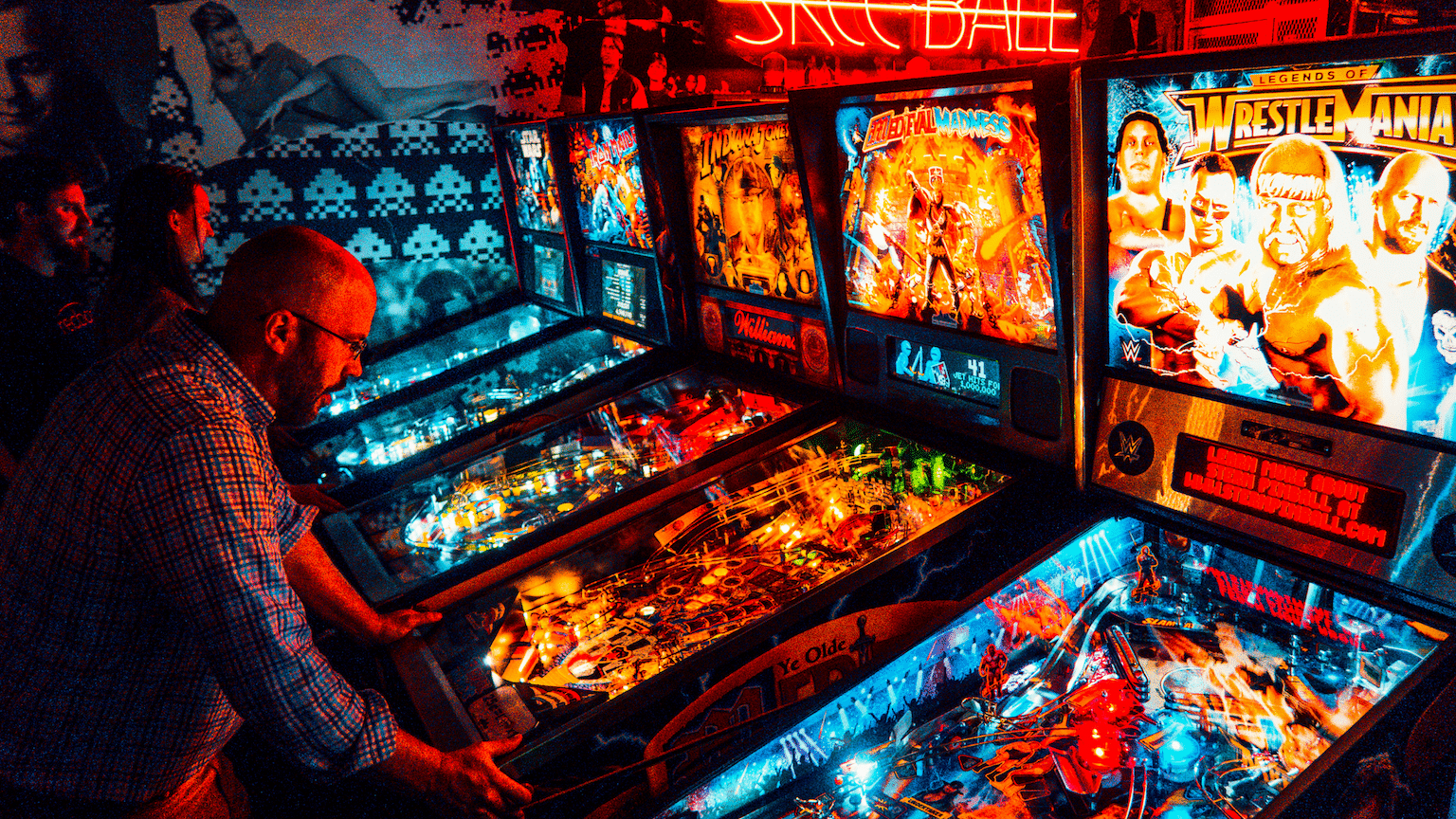 Colorful pinball machines with WWE and wrestling themed screens