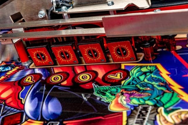 Colorful pinball machine with Deadpool-themed graphics and scoring display