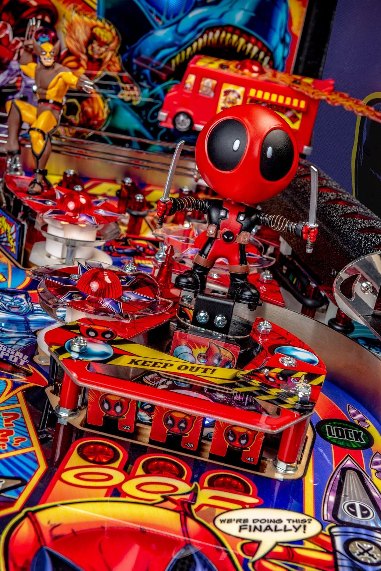 Colorful Deadpool-themed pinball machine with red robot and action figures