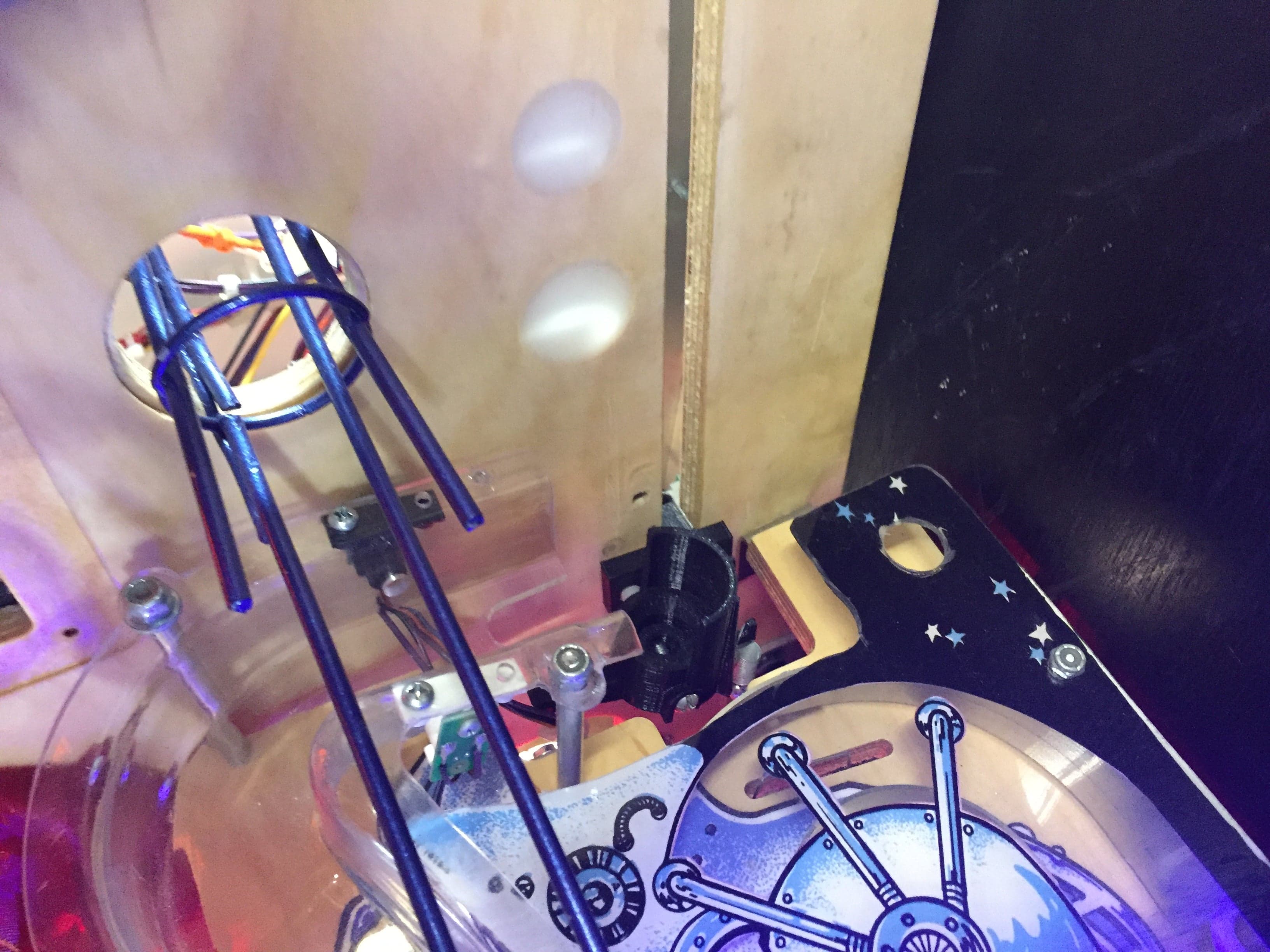 Mechanical device with blue metal parts, circuit board, and starry background