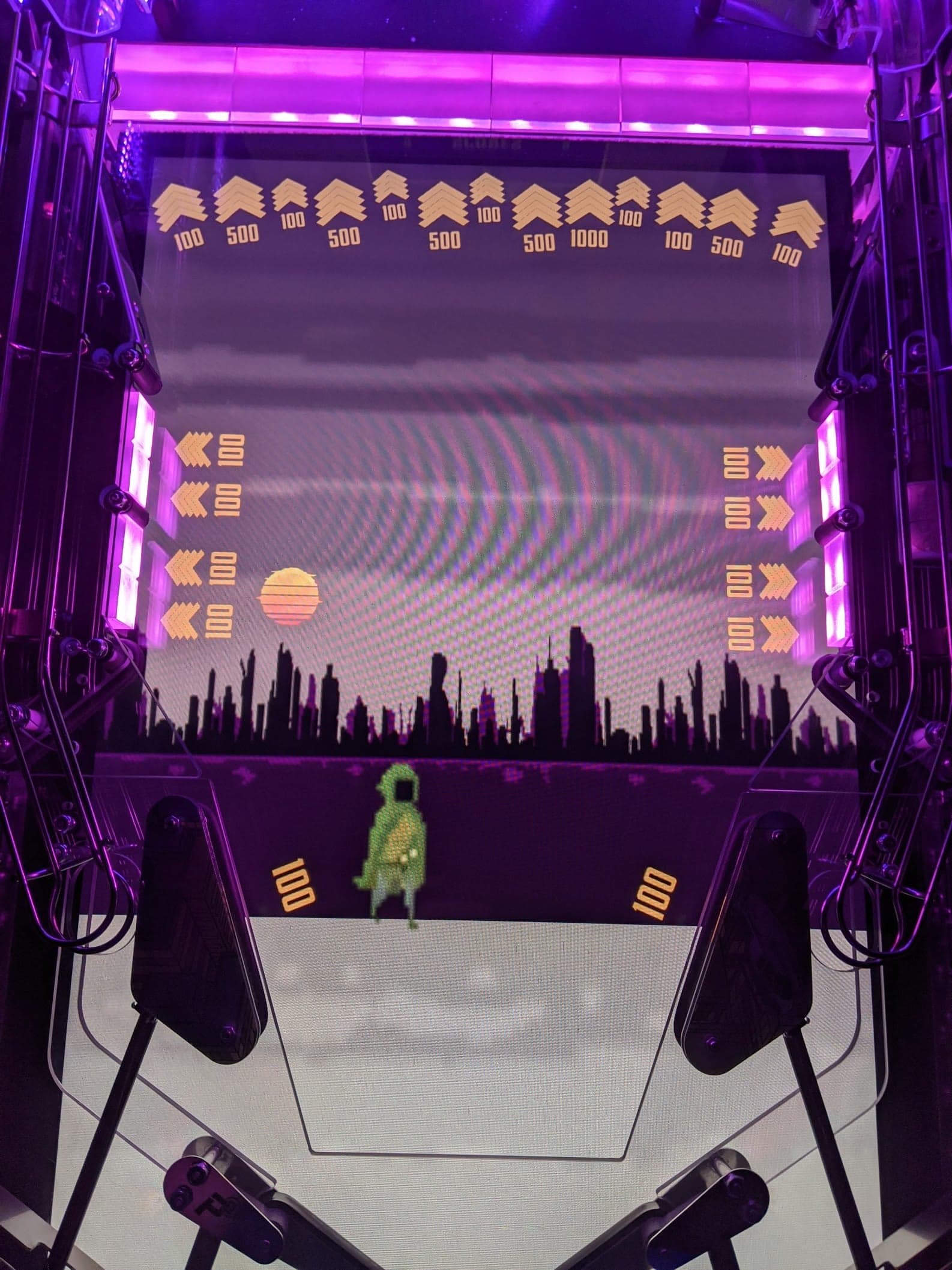 Retro arcade game screen with city skyline and pixelated green character