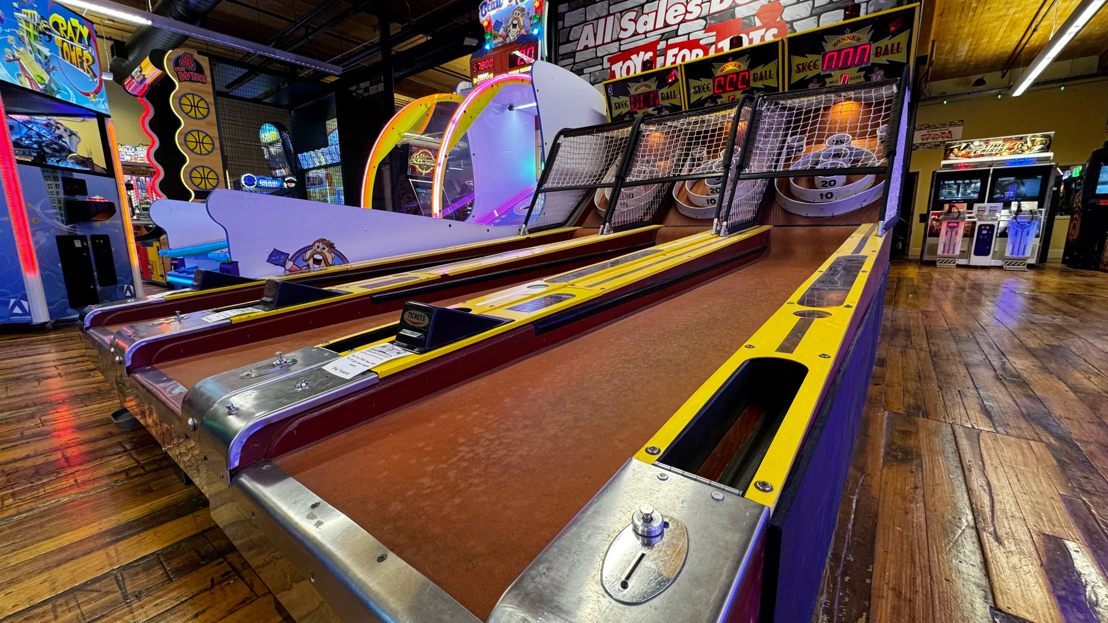 Colorful arcade with skee-ball lanes and arcade games in background