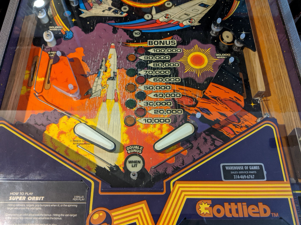 Vintage space-themed pinball machine with rockets and scoring display